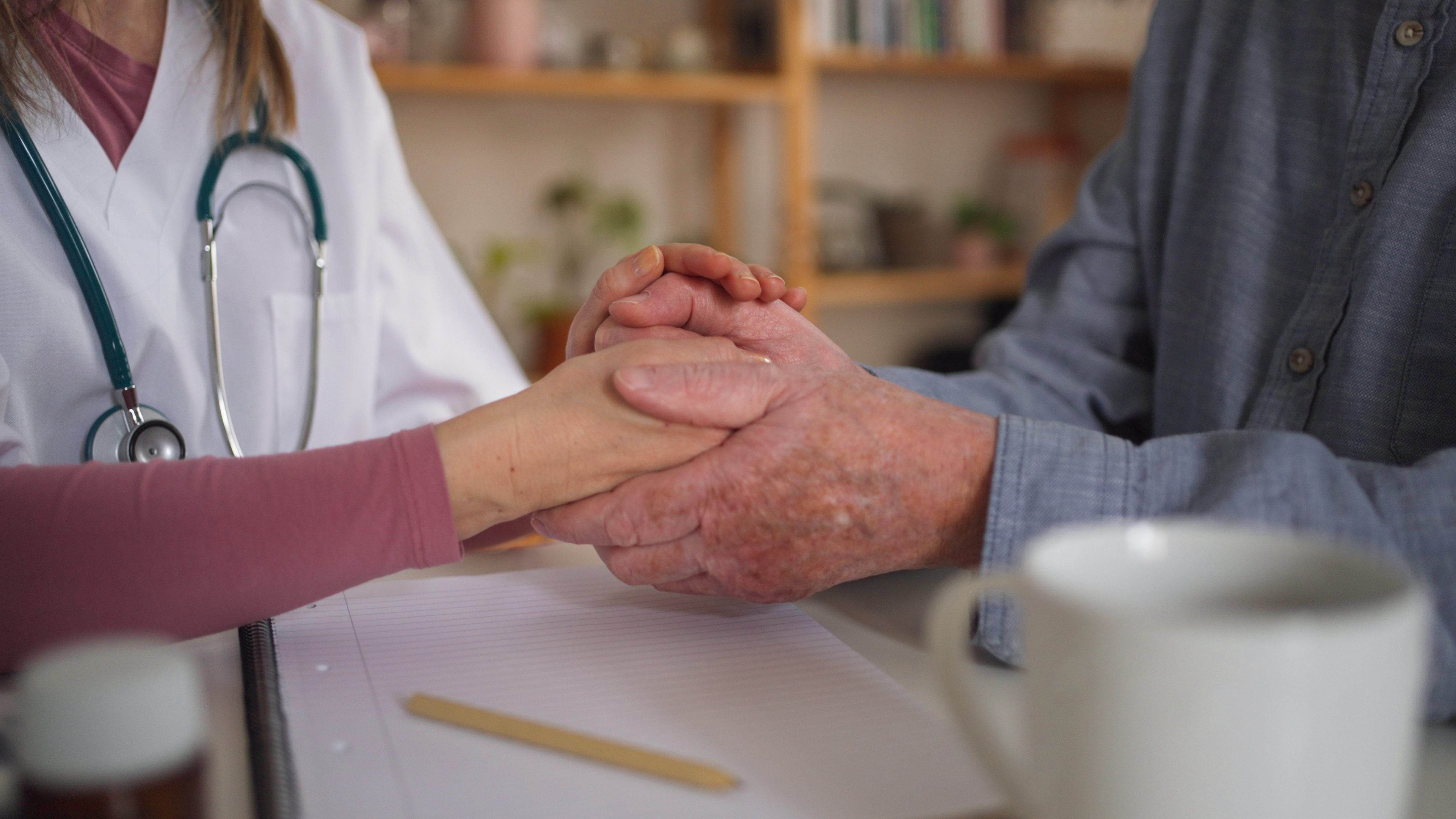 close up of doctor holding hand of senior patient and consoling him during medical vis SBI 350620601