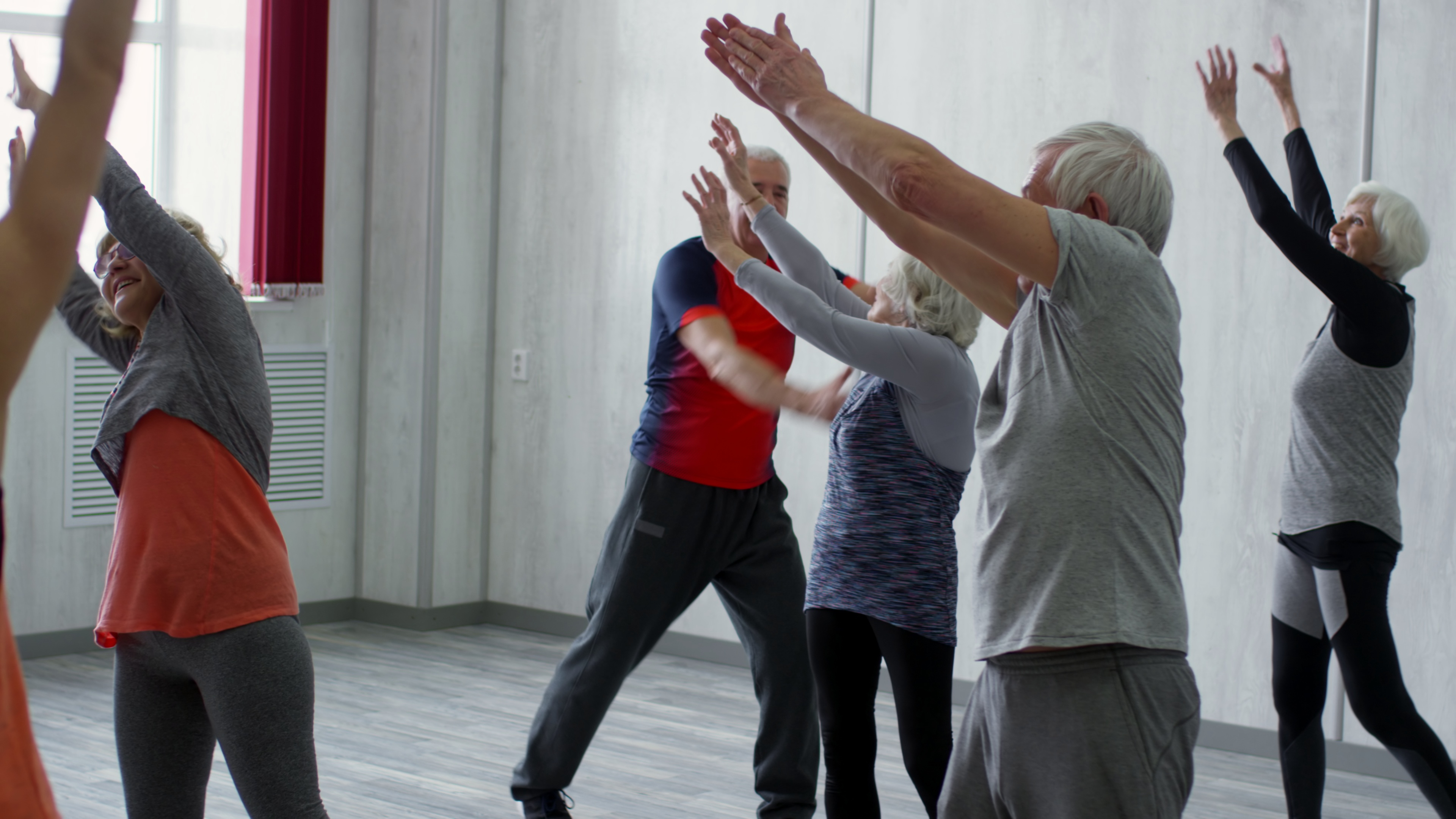 pan of female fitness trainer and happy senior people in sportswear doing dynamic stre SBI 349555160