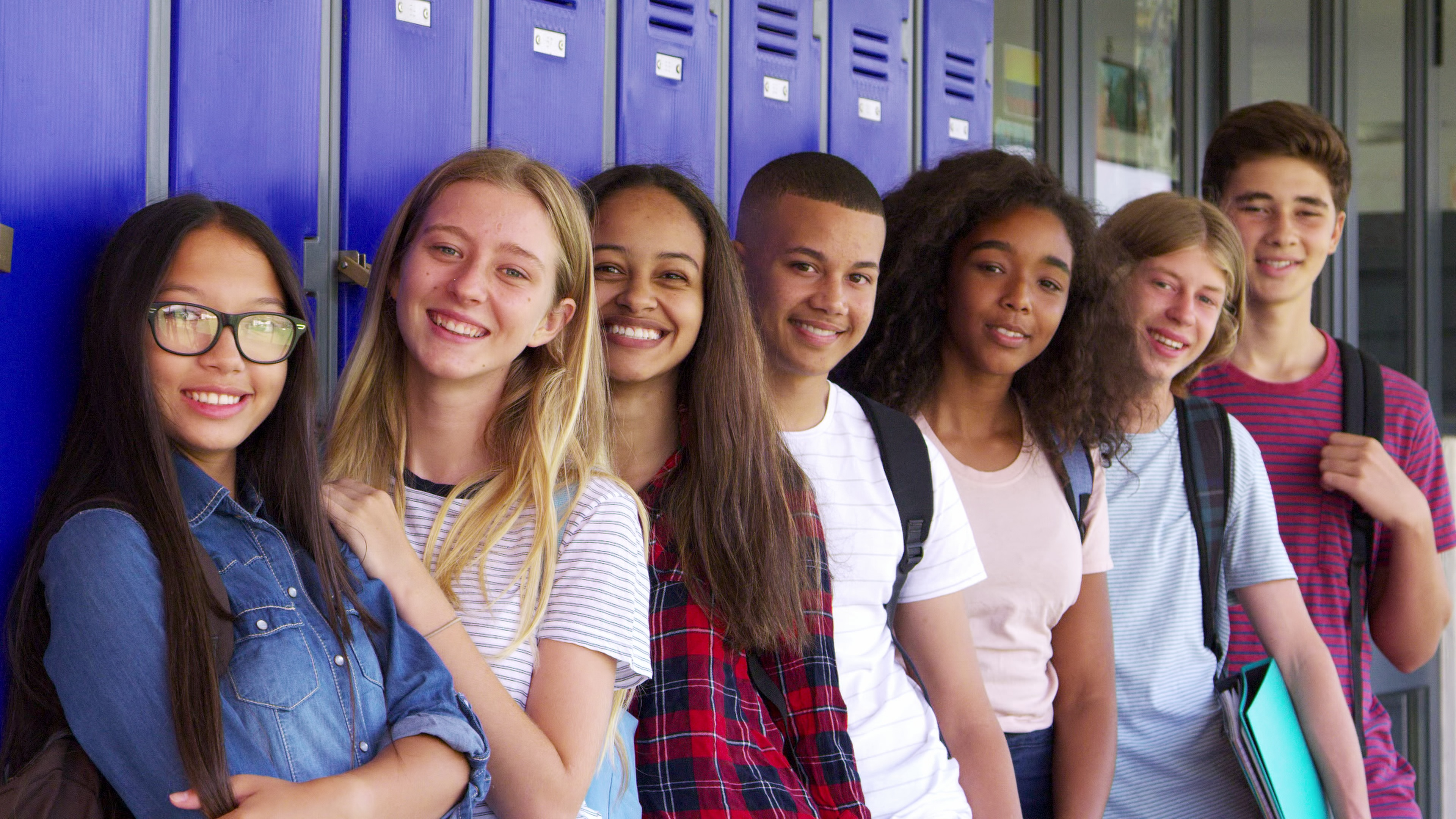 teenage school kids smiling to camera in school corridor SBI 350103941